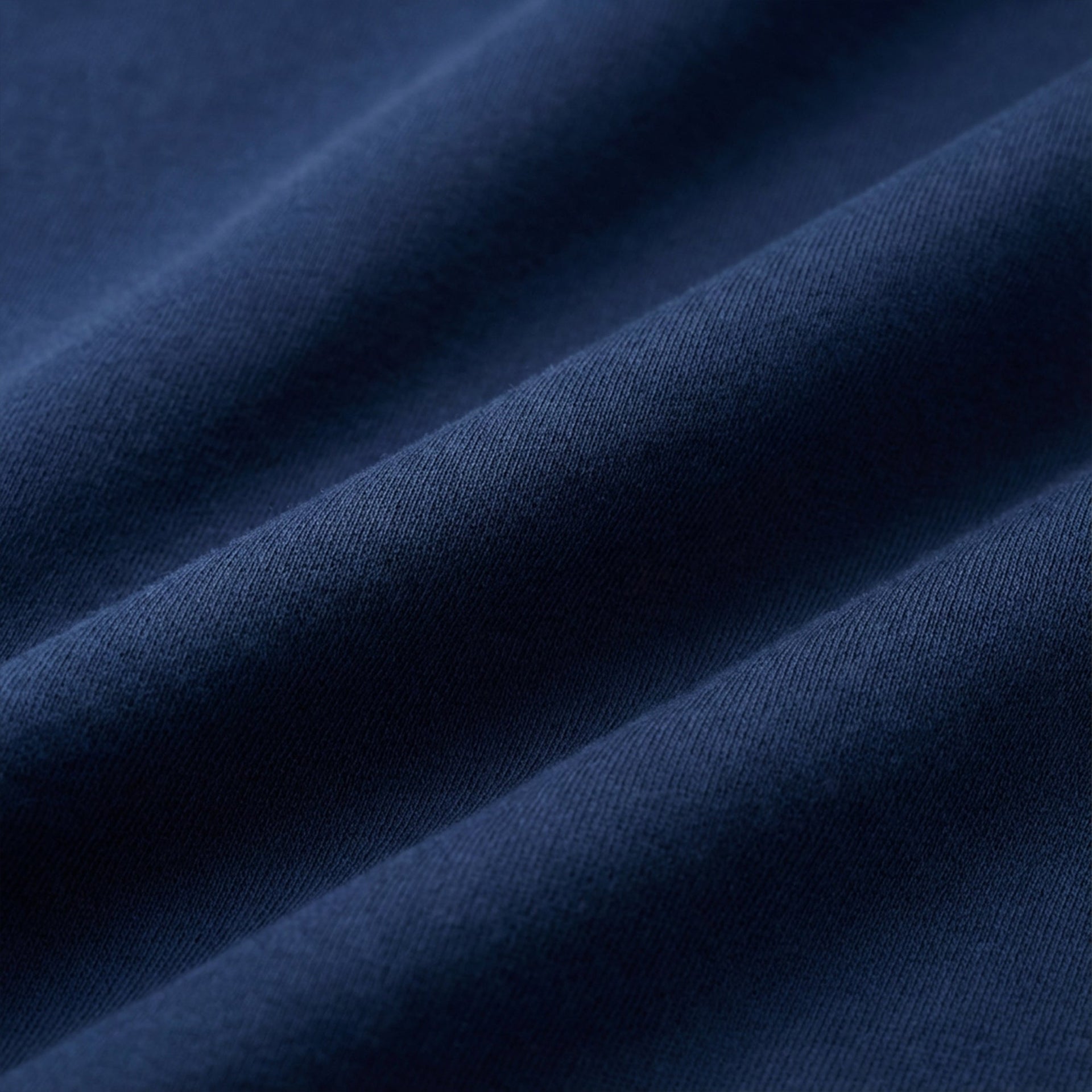 Close-up of navy organic cotton fabric showing soft textured knit by The Ei8ht.