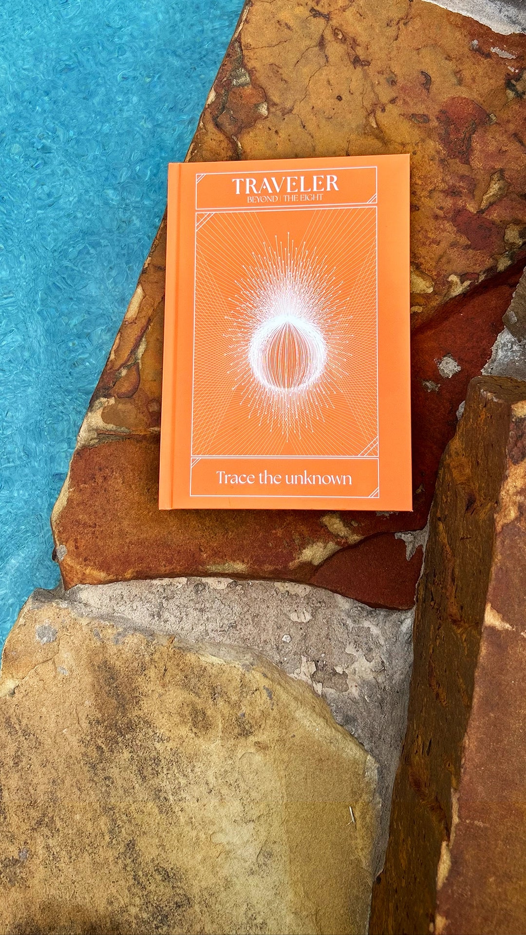 Traveler journal by The Ei8ht placed on natural stone background with "Trace the unknown" text.