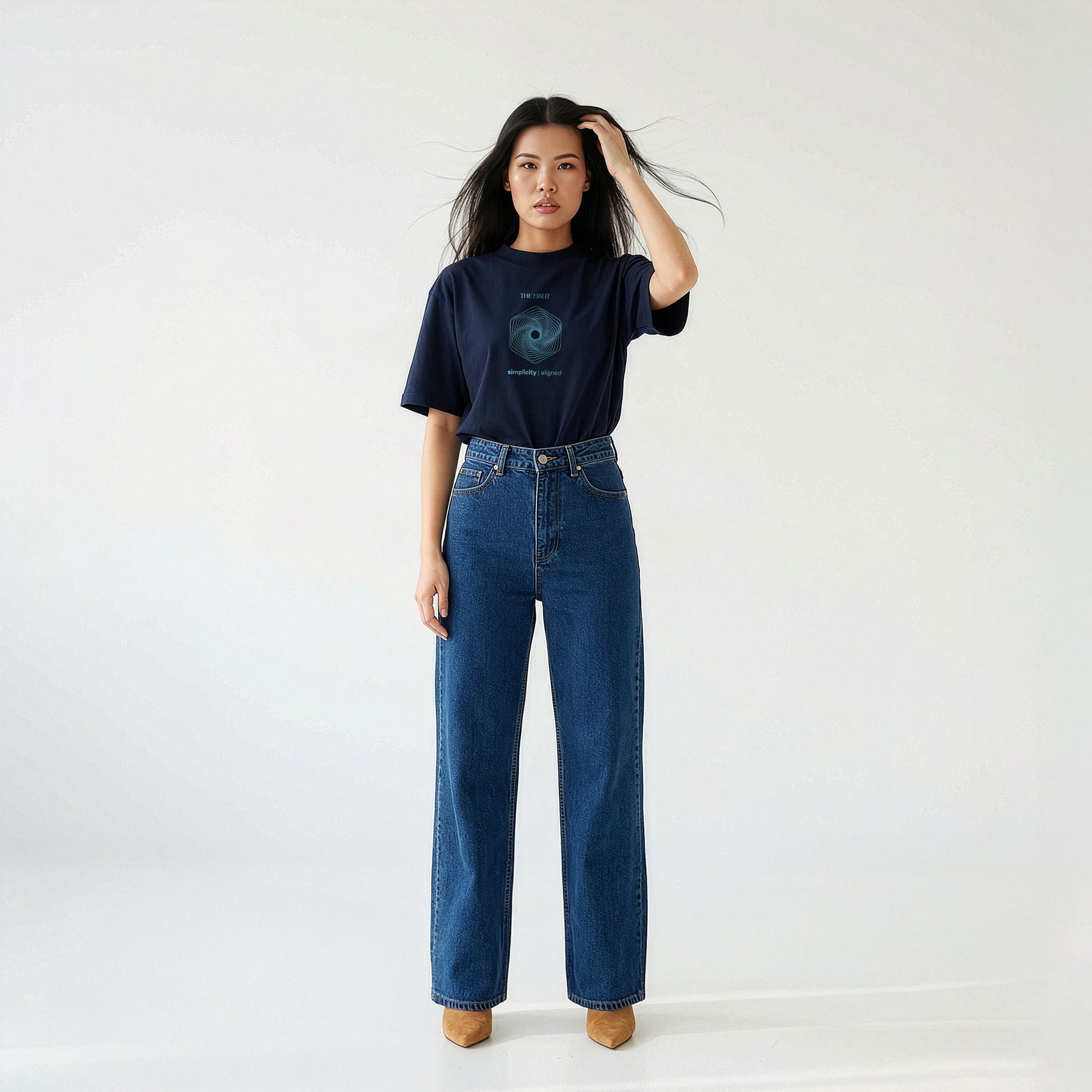Woman wearing navy oversized organic cotton t-shirt, styled with high-waisted jeans on neutral background.
